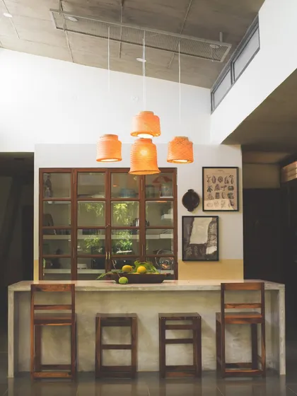 The kitchen island and upcycled pantry cabinet at 'Aamra'. This view shows how the kitchen is designed as the home's central hub, a place for both cooking and gathering, with custom furniture that blends service and served spaces.