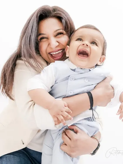 The pure, unadulterated laughter between a mother and her baby. This high-key portrait keeps the focus entirely on their joyful connection, creating a bright and timeless image.