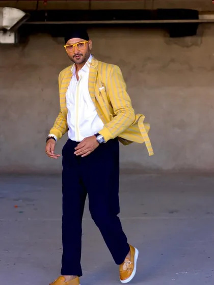 Another angle of Harbhajan Singh in the yellow blazer set. The combination of the bright jacket with dark trousers creates a balanced and modern semi-formal look.