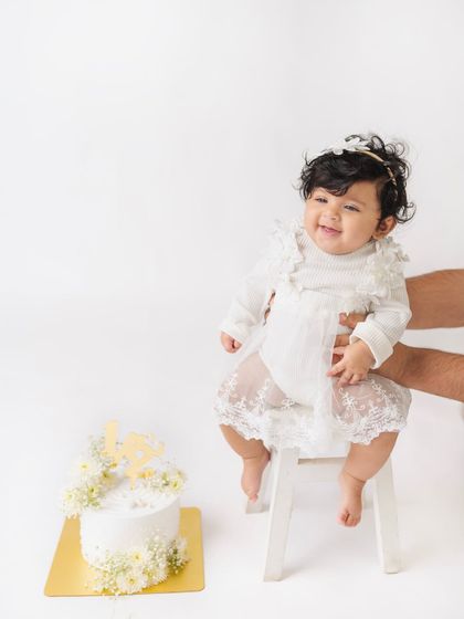 Such a happy smile for her half birthday. At six months, many babies can sit up, making it a wonderful age for portraits like this one on a little stool.