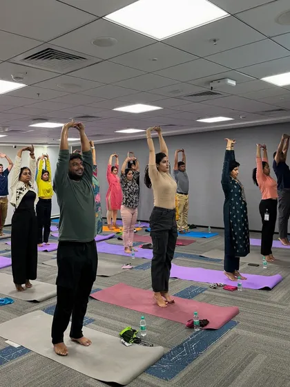 In a conference room at Manhattan Associates, I led a session focused on posture and flexibility. This standing stretch helps counteract the effects of sitting, promoting better alignment and energy flow for the entire team.