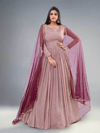 A beautiful dusty pink gown with a sheer maroon dupatta. The simple silhouette and elegant color make it a versatile choice.