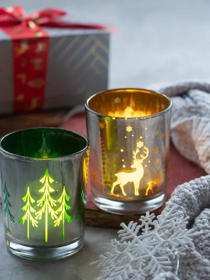 These beautiful mercury glass candle holders glow from within when a tea light is lit. They feature etched designs of Christmas trees and reindeer.