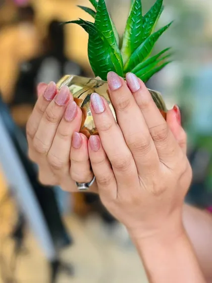 The pearly pink manicure is shown here, demonstrating its subtle shine and delicate color that's perfect for a touch of understated glamour.