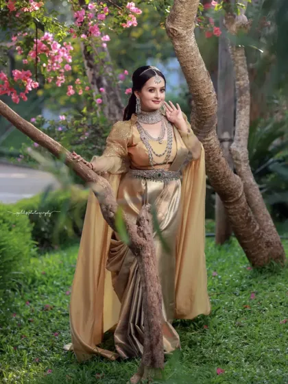 A full-length portrait that captures the grandeur of the golden gown against the natural beauty of the garden.