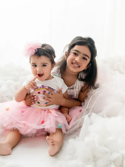 Sisters forever. This photo captures the sweet and protective hug of an older sister for her baby sister, nestled in a bed of clouds.