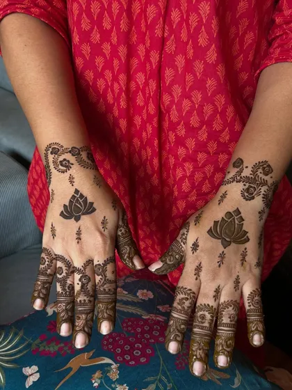 An Arabic-style design featuring a bold lotus as the main element, with delicate patterns trailing down the fingers.