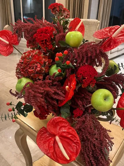 The secret ingredient is always love. And sometimes, it's also crisp green apples. This bold arrangement combines red anthuriums and amaranthus with the unexpected pop of green apples for a chic and modern tablescape.