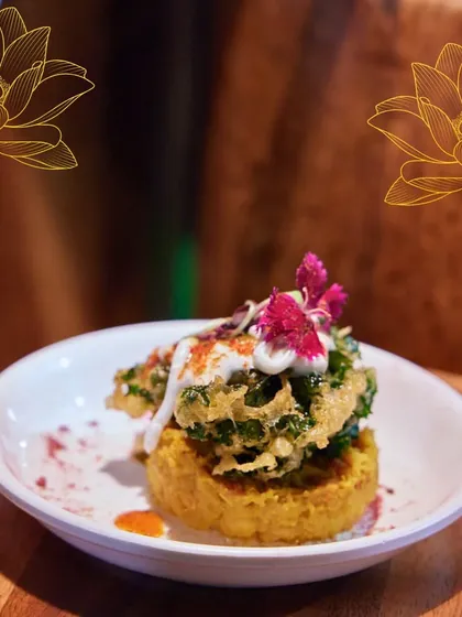 A unique appetizer featuring a crispy kale pakoda on a savory base. This dish highlights our love for contrasting textures and innovative flavour combinations.
