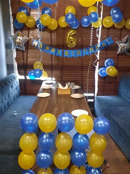 A blue and yellow themed decoration for a 6th birthday party at a restaurant.
