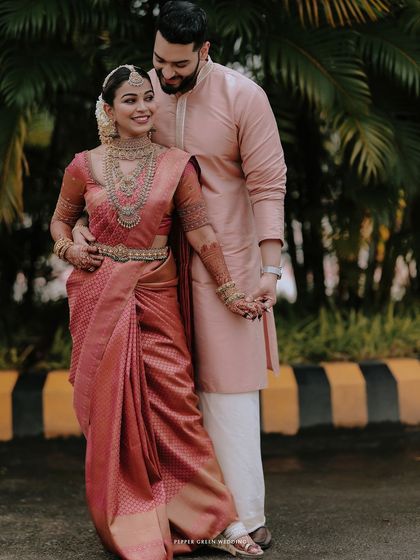 An elegant portrait of the couple, their traditional attire looking stunning against a backdrop of palm trees.