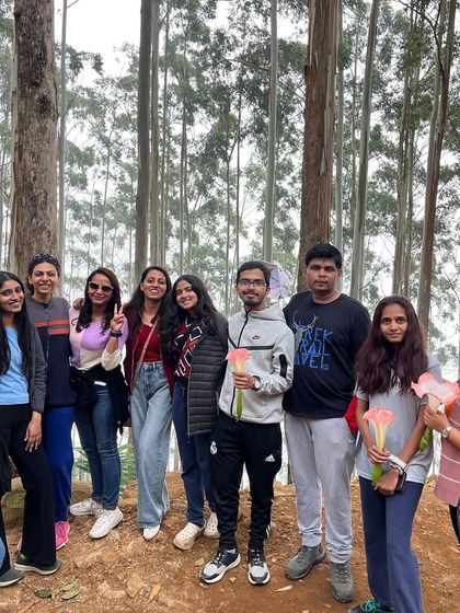 A group of friends amidst the tall trees of the Kodaikanal pine forest. It's a perfect backdrop for capturing the essence of your trip.