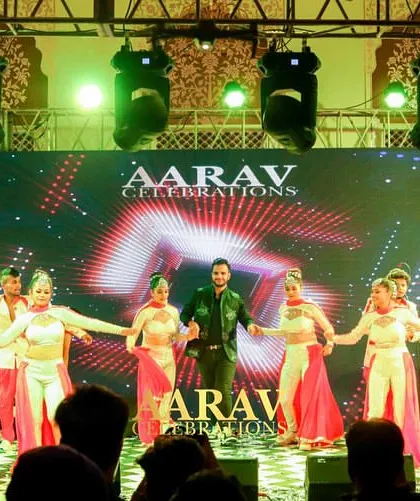 A full-scale sangeet performance at Chomu Palace. A family member takes the lead, backed by a large troupe of dancers in coordinated pink and white outfits, showcasing a professional-level production.