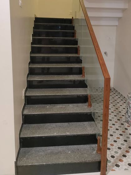 A simple yet elegant glass railing with a wooden handrail for an internal staircase. This is a practical and stylish solution that fits well in many contemporary homes.