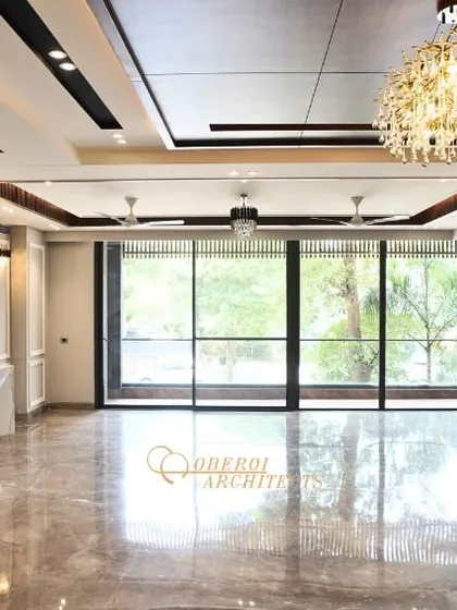 Another angle of the unfurnished living area, highlighting the elegant wall paneling and the stunning crystal chandelier.