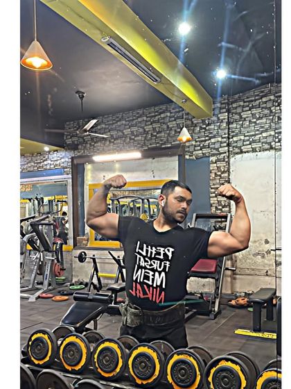 Double biceps pose by the dumbbell rack. This is my element.