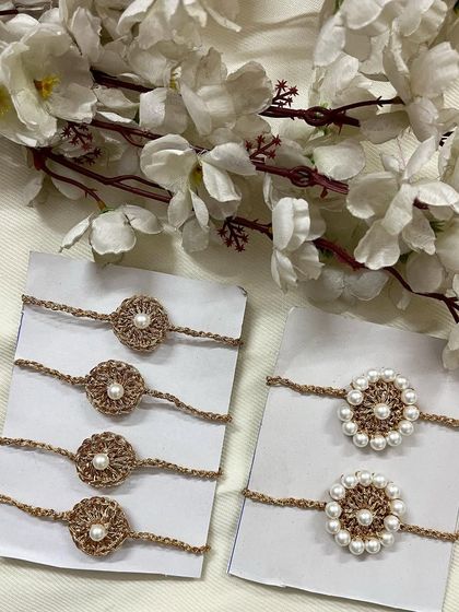 My elegant pearl handmade crochet rakhis are crafted with a beautiful golden thread. You can see two variations here, one with a simple pearl center and another with a full pearl border.