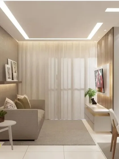 A cozy living room setup with a simple sofa and a floating TV unit against a wood-paneled wall. The sheer curtains allow natural light to fill the room, creating a warm and inviting atmosphere.