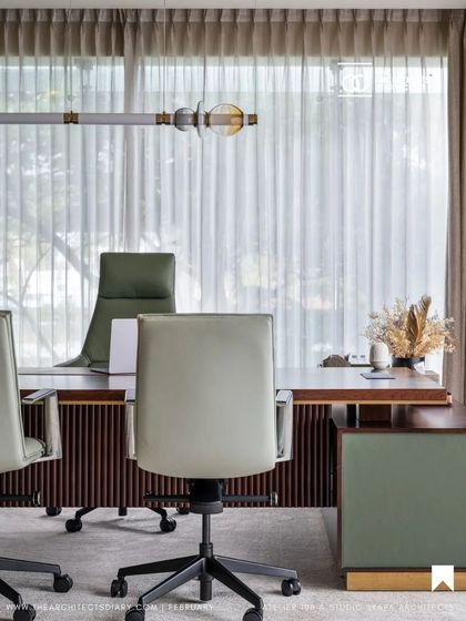 An executive desk setup from the Meghana Foods project, highlighting the use of rich materials and natural light to create a powerful and pleasant workspace.