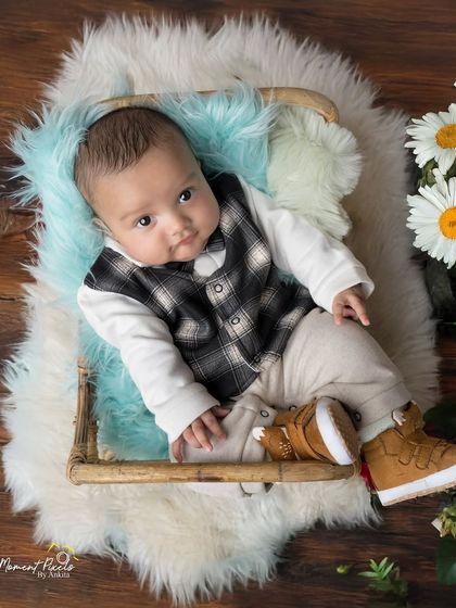 Dressed to charm and ready for his close-up. This little gentleman in his plaid vest and boots looks so dapper in this rustic, floral setup.