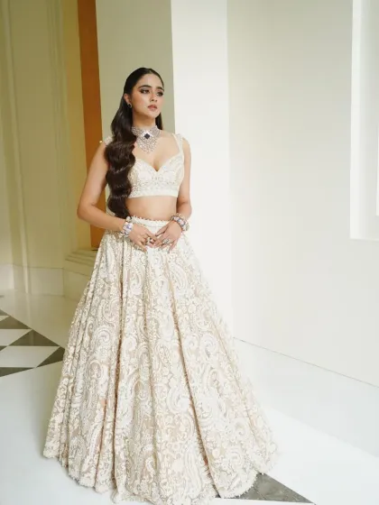 This shot showcases the beautiful A-line silhouette of the lehenga and the bride's poised and graceful stance.