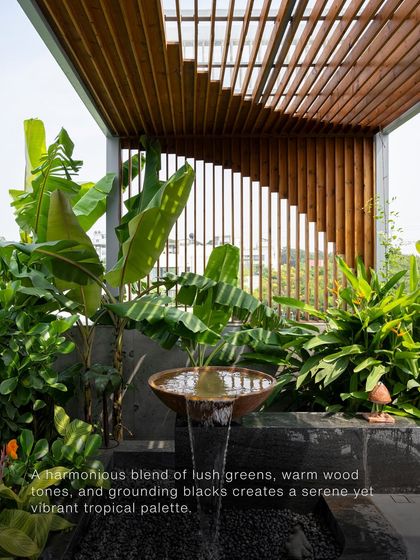 The realization of the tropical palette, with a water feature surrounded by lush plants, a wooden pergola, and stone elements. This shows how the initial mood board translates into a real, sensory space.