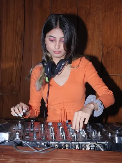 A close-up shot of me at the decks, focused on the mix. You can see the detail of the Pioneer mixer and my hands at work.