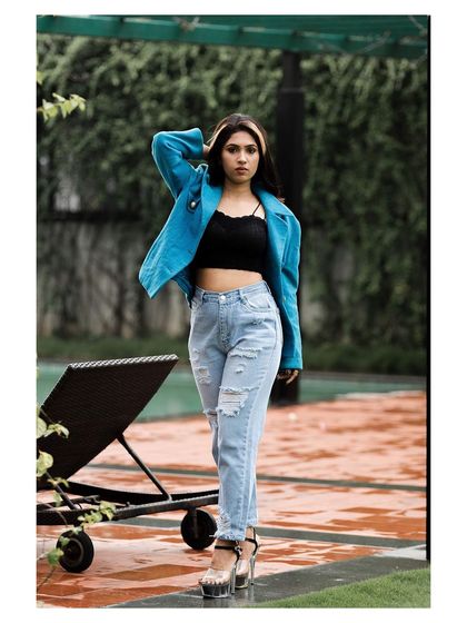 An outdoor fashion shot with a cool, urban vibe. The model's confident stance and stylish outfit create a modern and edgy look.