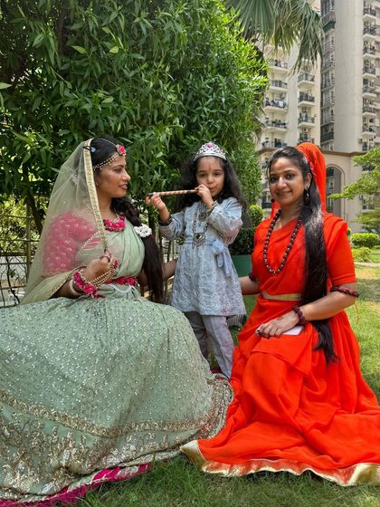 A lovely outdoor shot of a client in her mint green lehenga, posing with her family.