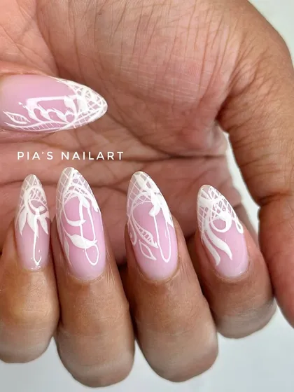 A closer view of the detailed white lace nail art, showing the fine lines and patterns that make this design so special.