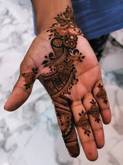 A simple yet elegant Arabic vine design on the palm. This style is great for guests at a wedding or for any festive occasion where you want a touch of henna.