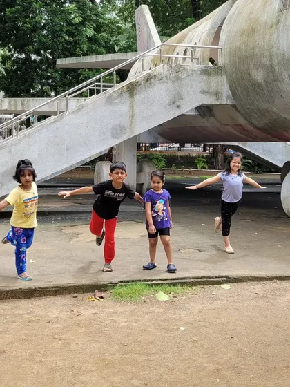 The kids are having fun with Virabhadrasana III (Warrior III Pose), pretending to be airplanes. Incorporating imagination and play helps children engage deeply with the practice and its benefits.
