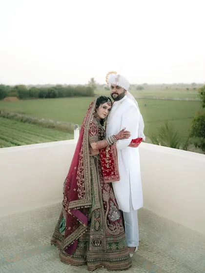 A loving embrace, showcasing the couple's connection and the stunning detail of their North Indian wedding outfits.