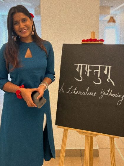 A participant poses happily next to the event signage.