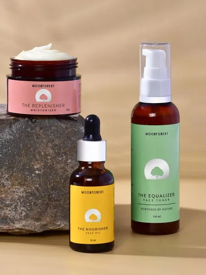 A group shot of Moon Forest's skincare line, styled with a natural rock. This composition highlights the product range while maintaining an earthy, grounded aesthetic.