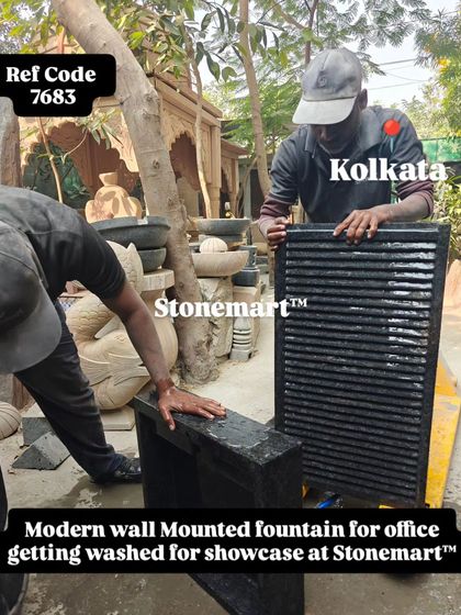 Two of my artisans wash a modern wall-mounted fountain to showcase its features. This is part of my quality control process.