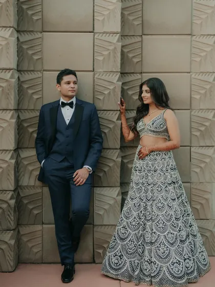 A modern and stylish portrait against a textured wall. The bride's playful glance at the groom adds a touch of personality and charm to this beautifully composed shot.