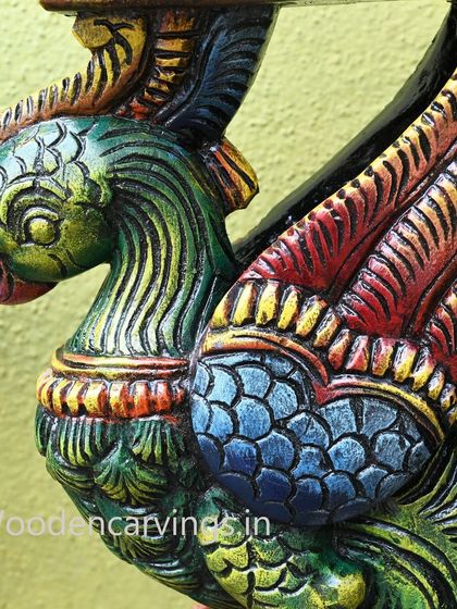 An extreme close-up on the head of the green parrot bracket, showing the detailed carving of its beak and the texture of its feathers.