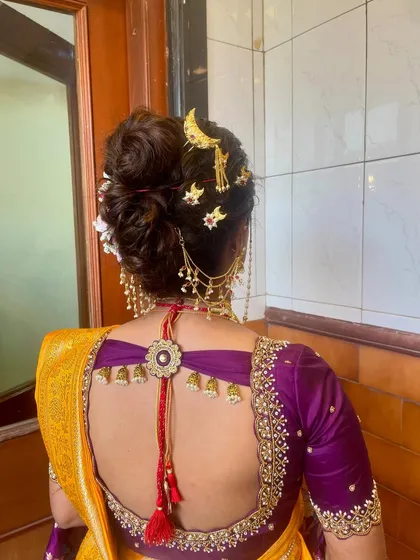 The back view of an elegant bridal bun, or Khopa, decorated with a chandrakor and other traditional hairpins.