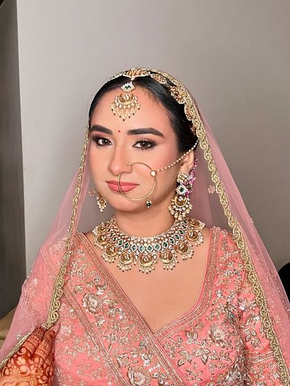 A closer look at this pretty-in-pink bride. The makeup is perfectly balanced, with defined brows, a delicate winged liner, and a soft matte pink lip that completes the look.