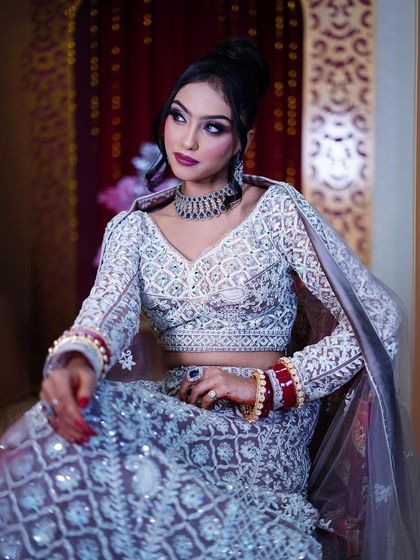 A seated portrait that shows the beautiful fall of the lehenga and the detailed blouse.