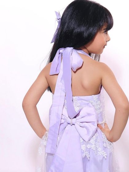 The back of our lilac lace dress, showing the elegant tie and bow detail. This is a great example of how we can customize features to create your perfect look.