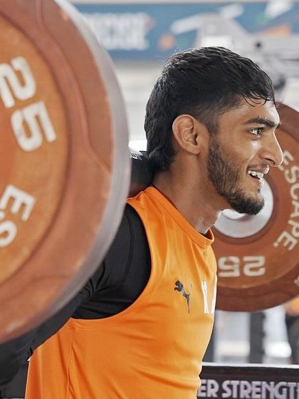 The grind is where champions are made. An athlete performing a heavy back squat, a foundational exercise for building lower body strength and power.