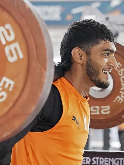 The grind is where champions are made. An athlete performing a heavy back squat, a foundational exercise for building lower body strength and power.