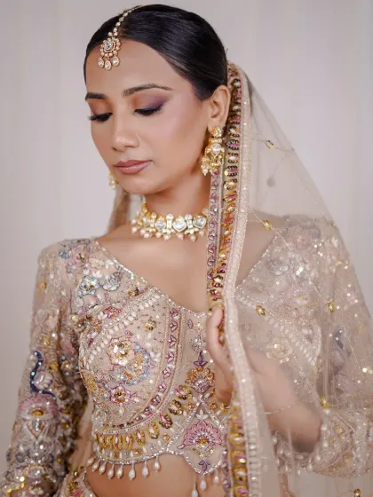 A close-up showing the soft makeup and the delicate embroidery on the dupatta and blouse.