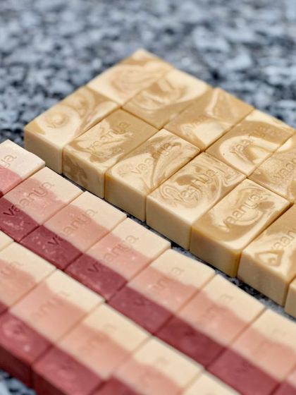 A close-up of the beautiful textures and colors of the Sweet Rose and Haldi Doodh soaps, custom-made in a smaller 50-gram size for event gifting.