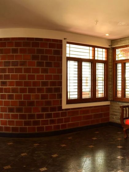 An interior space with a curved exposed brick wall, demonstrating how we use natural materials to create soft, flowing lines within a room.