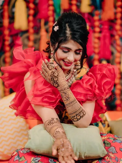 The bride's happiness is what matters most! Her beautiful smile shines against the colorful backdrop we created for her Mehendi.