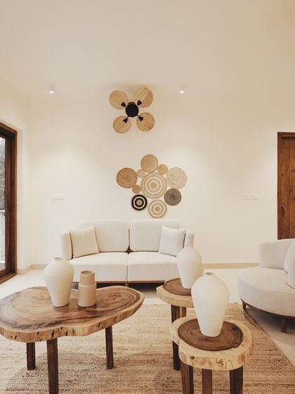 Another living space in the villa continues the theme of natural elegance. A live-edge coffee table and side tables made from tree stumps are paired with a clean-lined sofa, showcasing a beautiful balance of rustic and modern design.