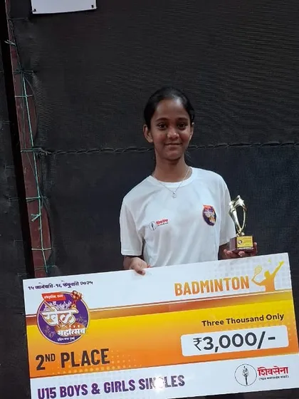 Akshara Jadhav, runner-up in the U15 Girls Singles at Khel Mahotsav 2025, holding her prize money and trophy.